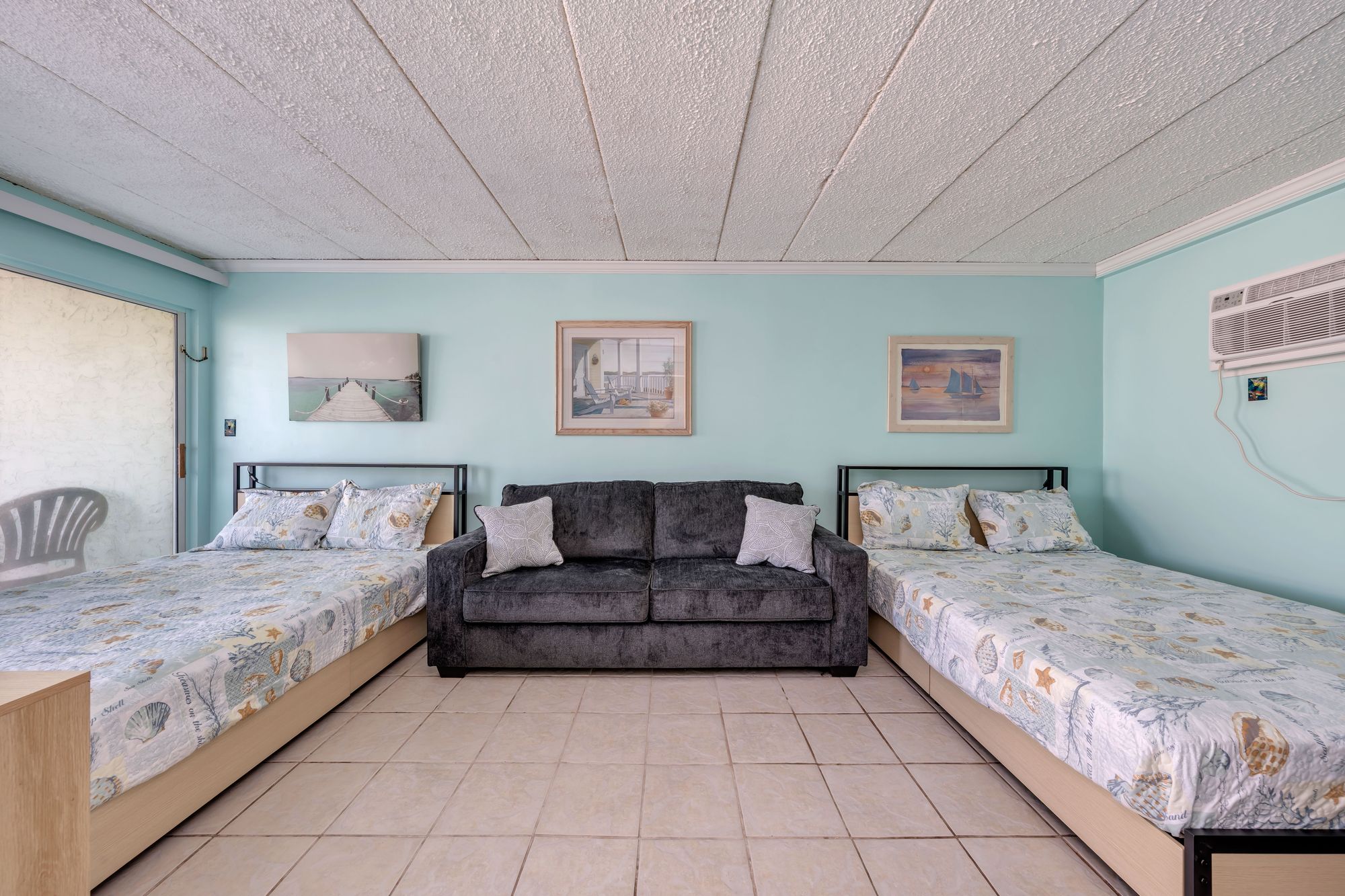 Bedroom with two queen beds and a gray queen sleeper sofa