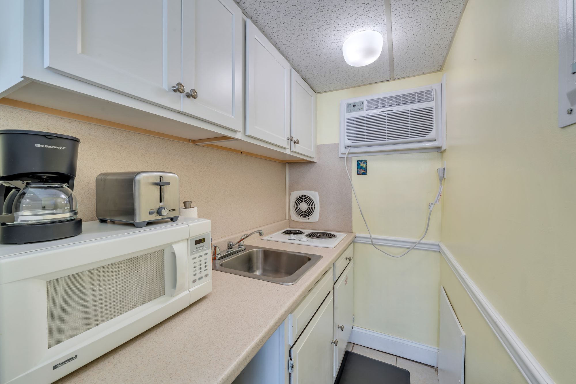 Kitchen with cooktop, microwave, toaster, and coffee maker